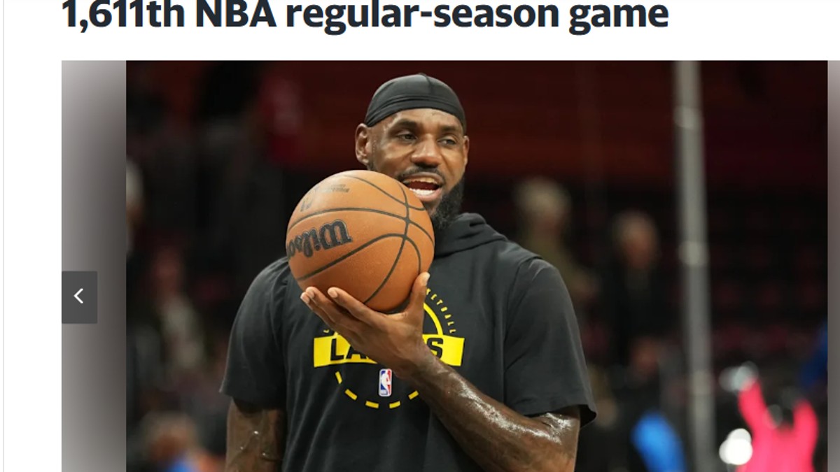 LeBron James holding basketball during Lakers vs Heat game after equaling NBA record of 1611 games